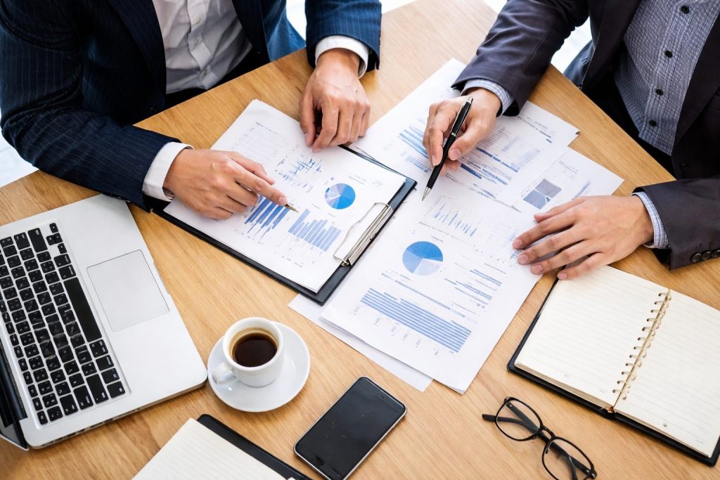 Overhead view of a business consultant discussing documents with a client during a consulting session